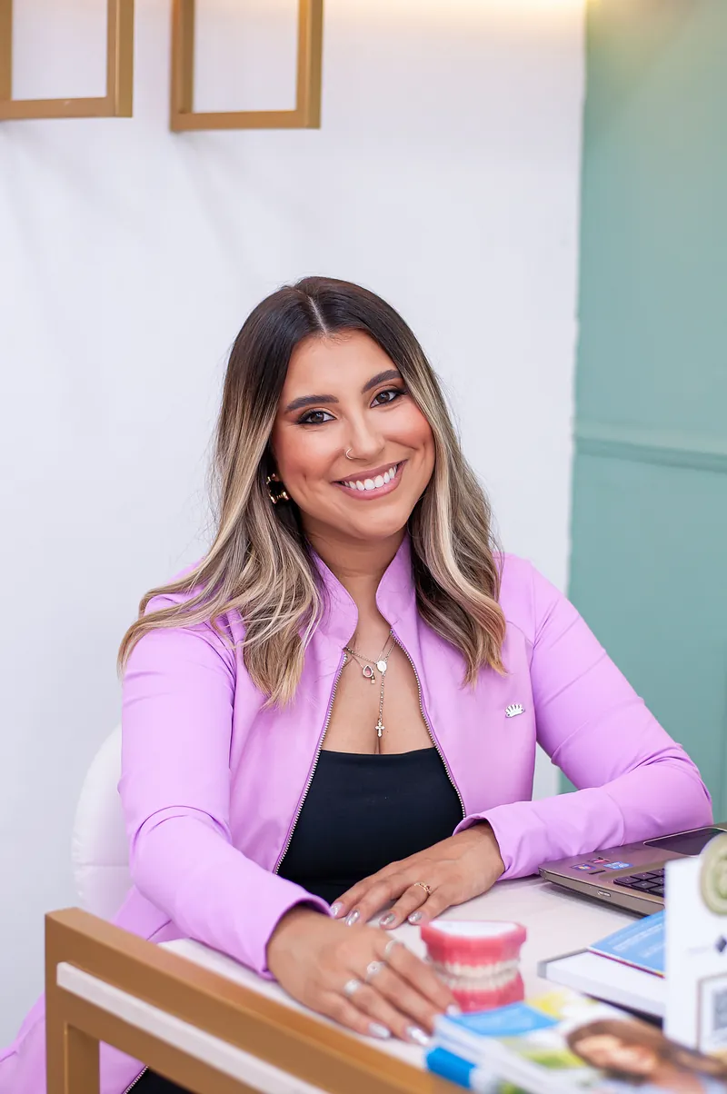 Dra. Tiffany Solimã em sua mesa de atendimento com modelos e materiais de Invisalign