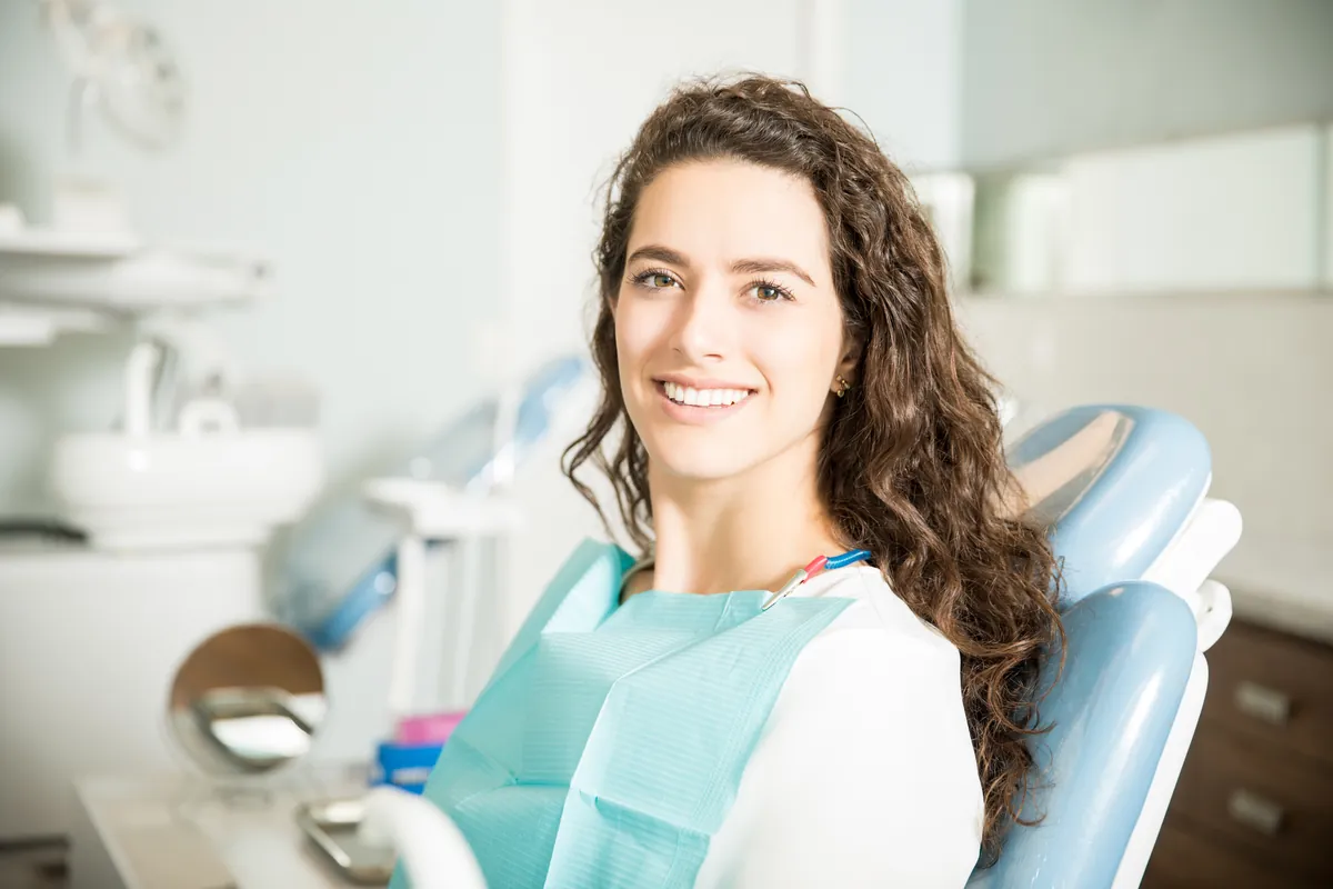 Paciente sorrindo na cadeira odontológica